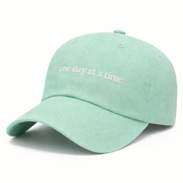 Mint green cap with inspiring message "one day at a time"